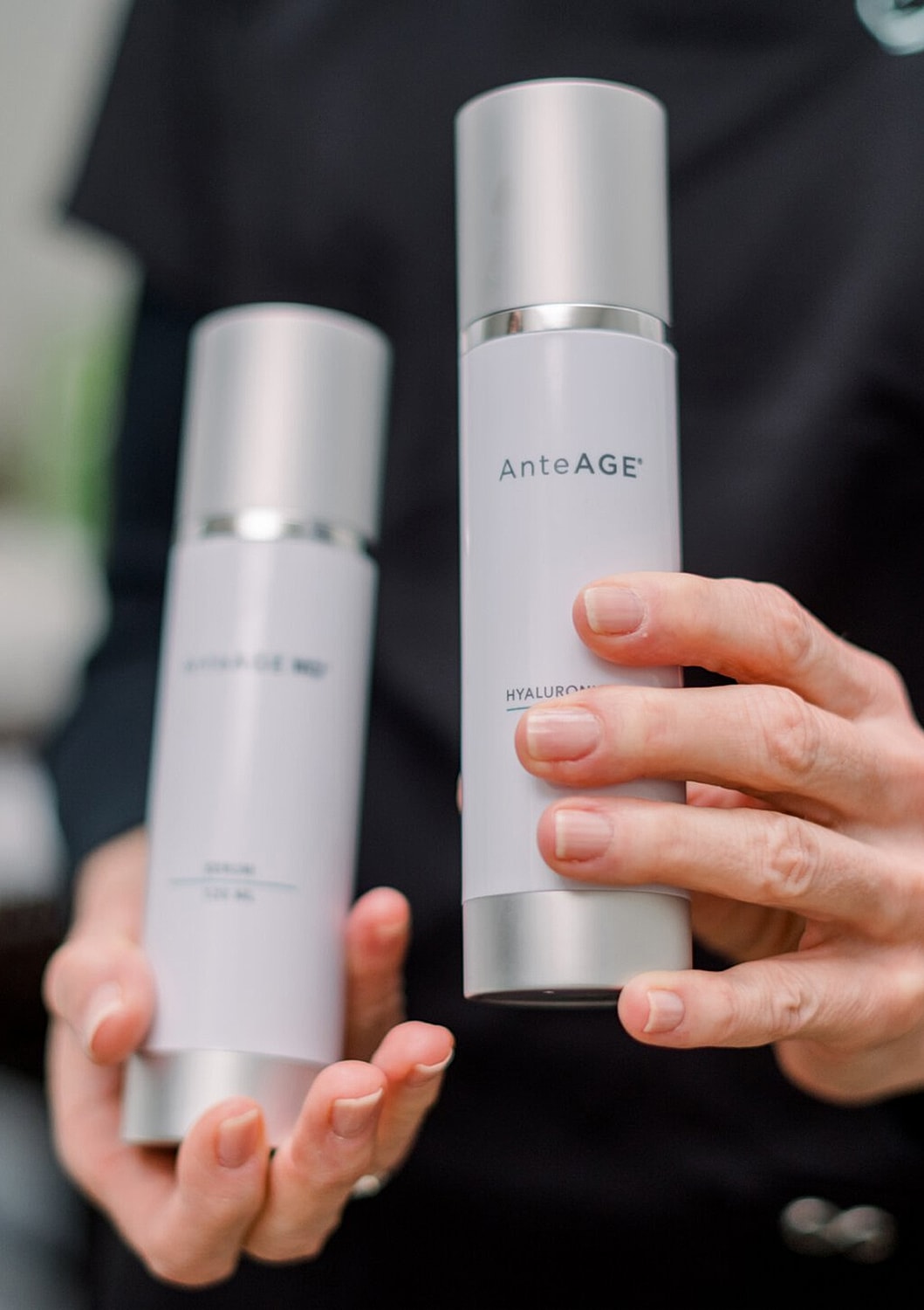 AnteAGE skincare bottles held in hands.