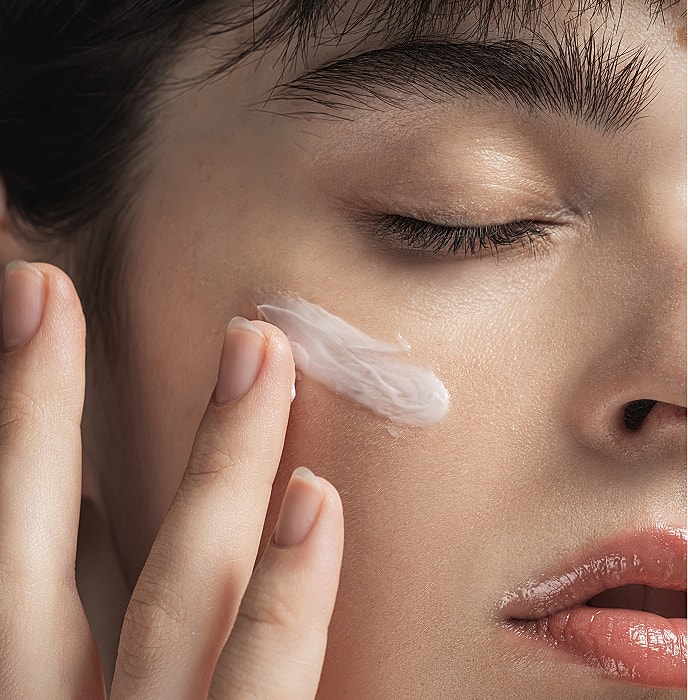 Applying moisturizer on facial skin.
