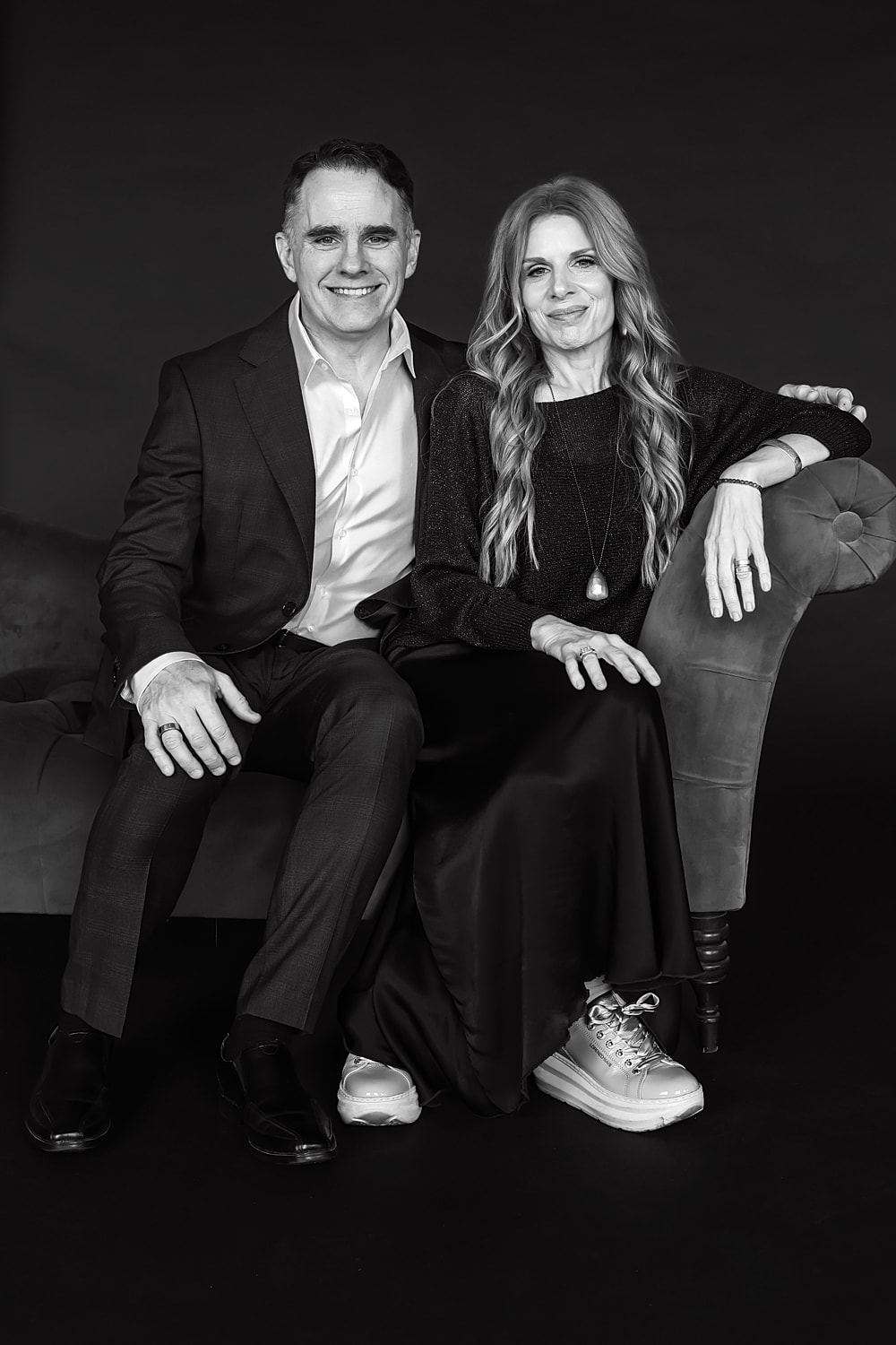 Couple posing together on a vintage couch.