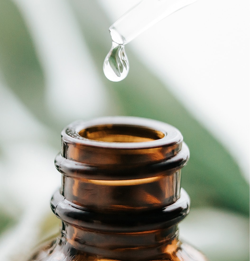 Dropper releasing liquid from amber glass bottle