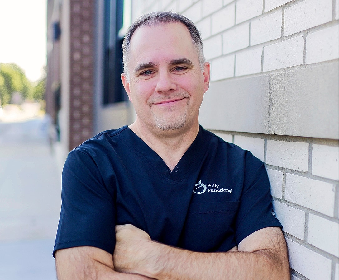 Professional man smiling against brick wall.