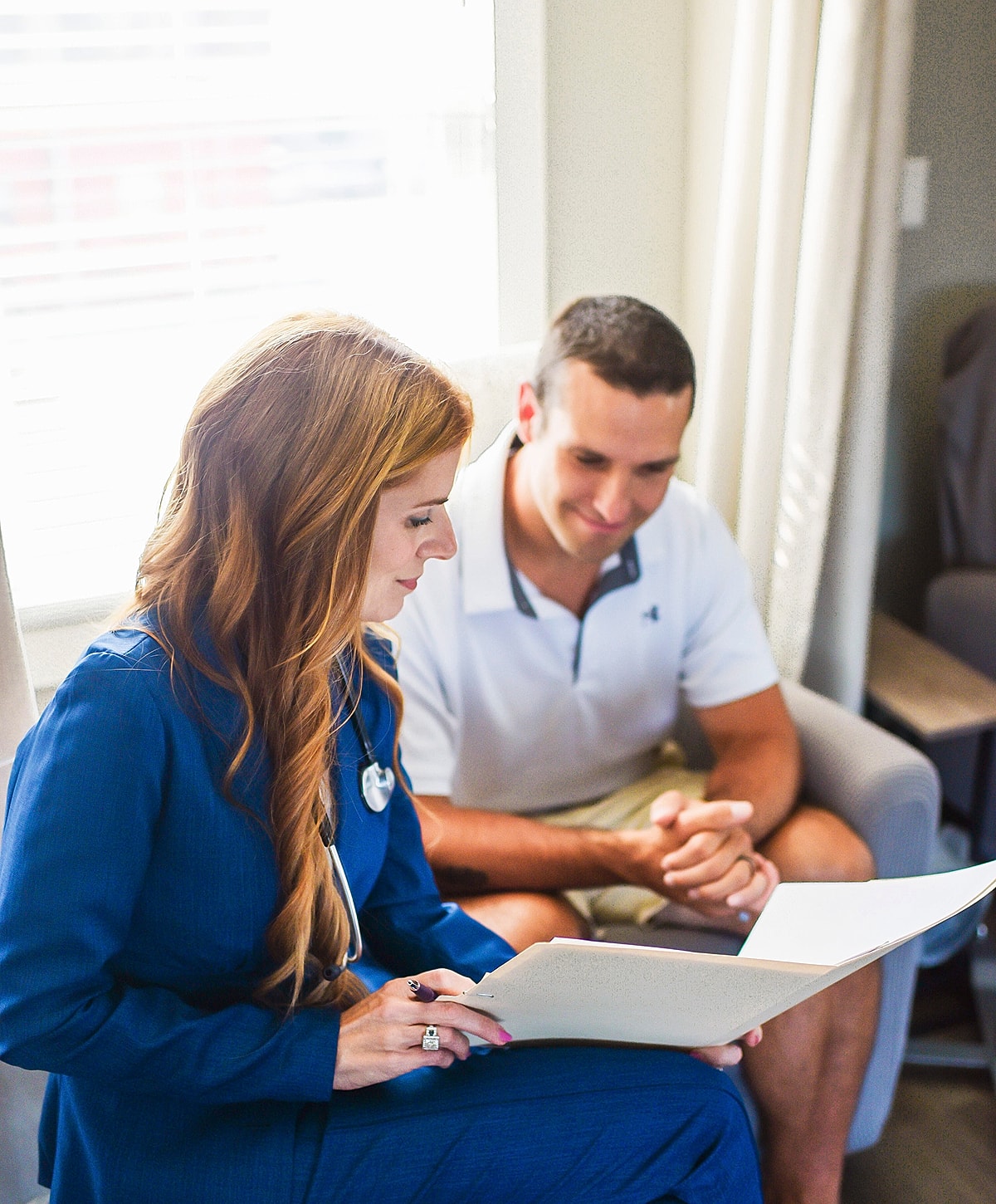 Healthcare professional reviewing documents with patient.