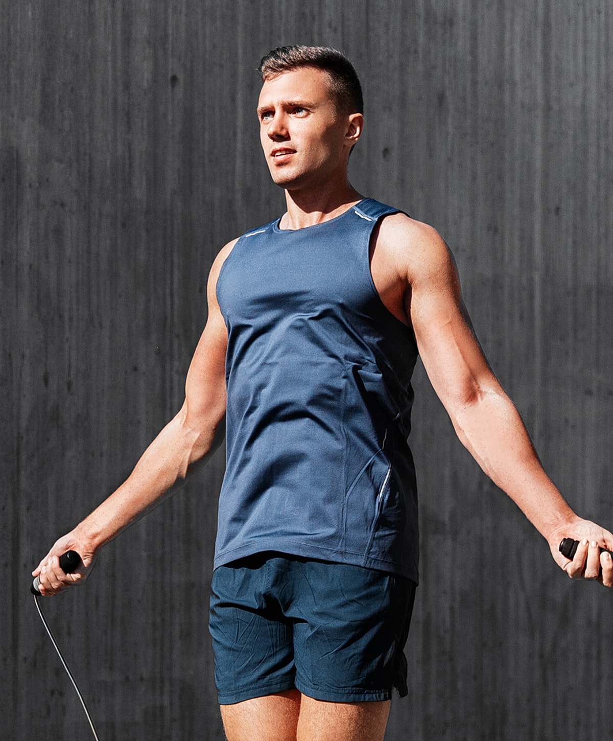 Man exercising with jump rope indoors.