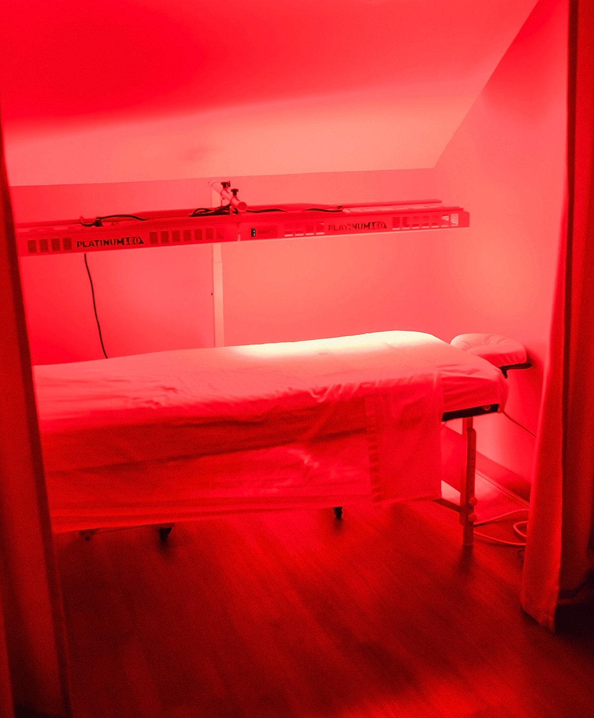 Red light therapy treatment room with massage table.