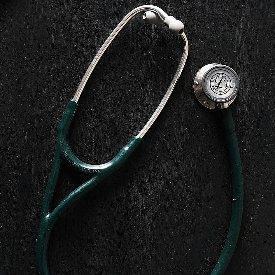 Green stethoscope on a dark background.