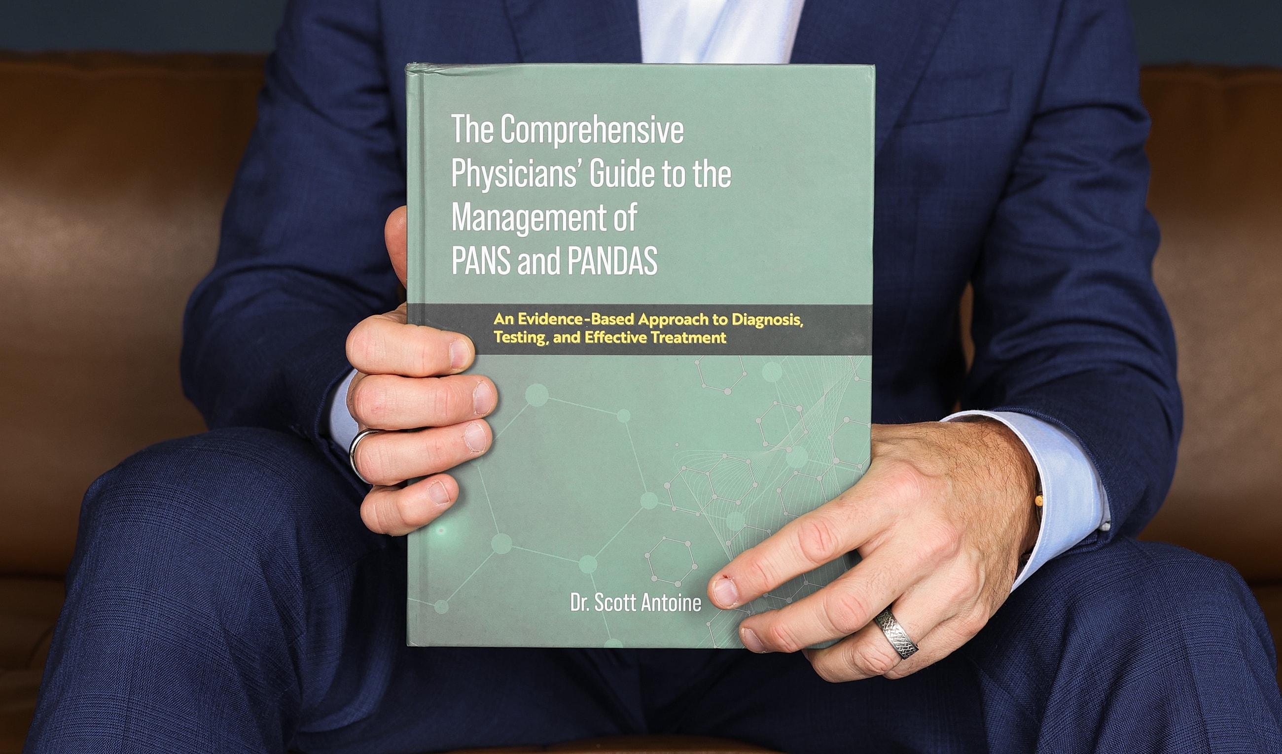 Person holding book on PANS and PANDAS management.
