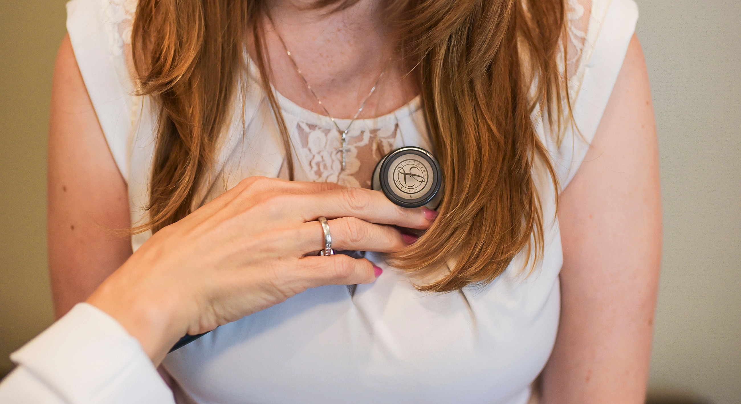 Woman using a stethoscope on another individual.