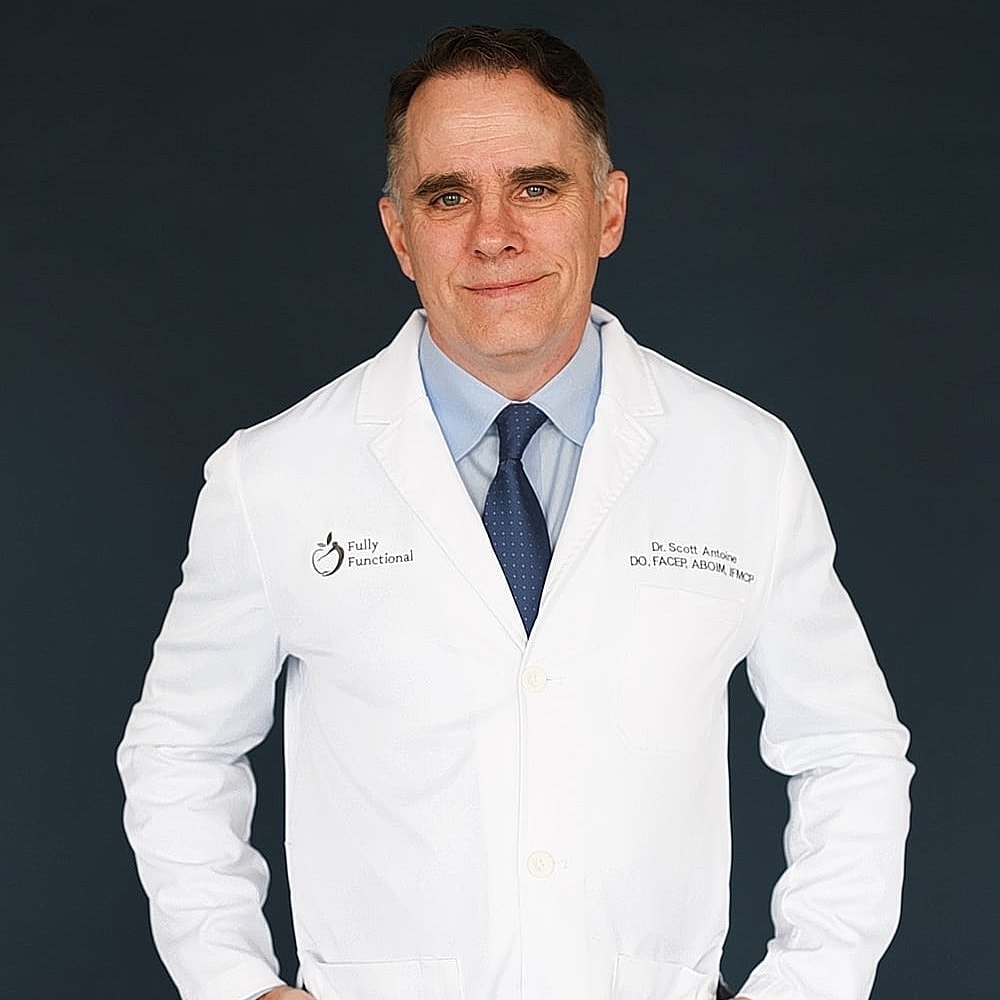 Doctor in a white lab coat, smiling at camera.